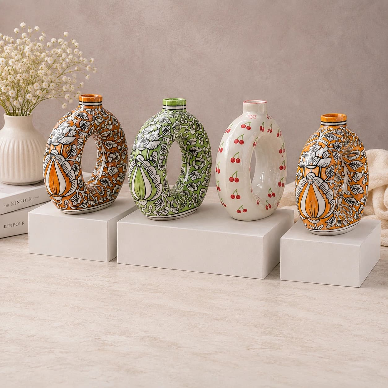 Patterned ceramic vases displayed on white plinths
